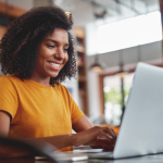 woman in yellow shirt using laptop