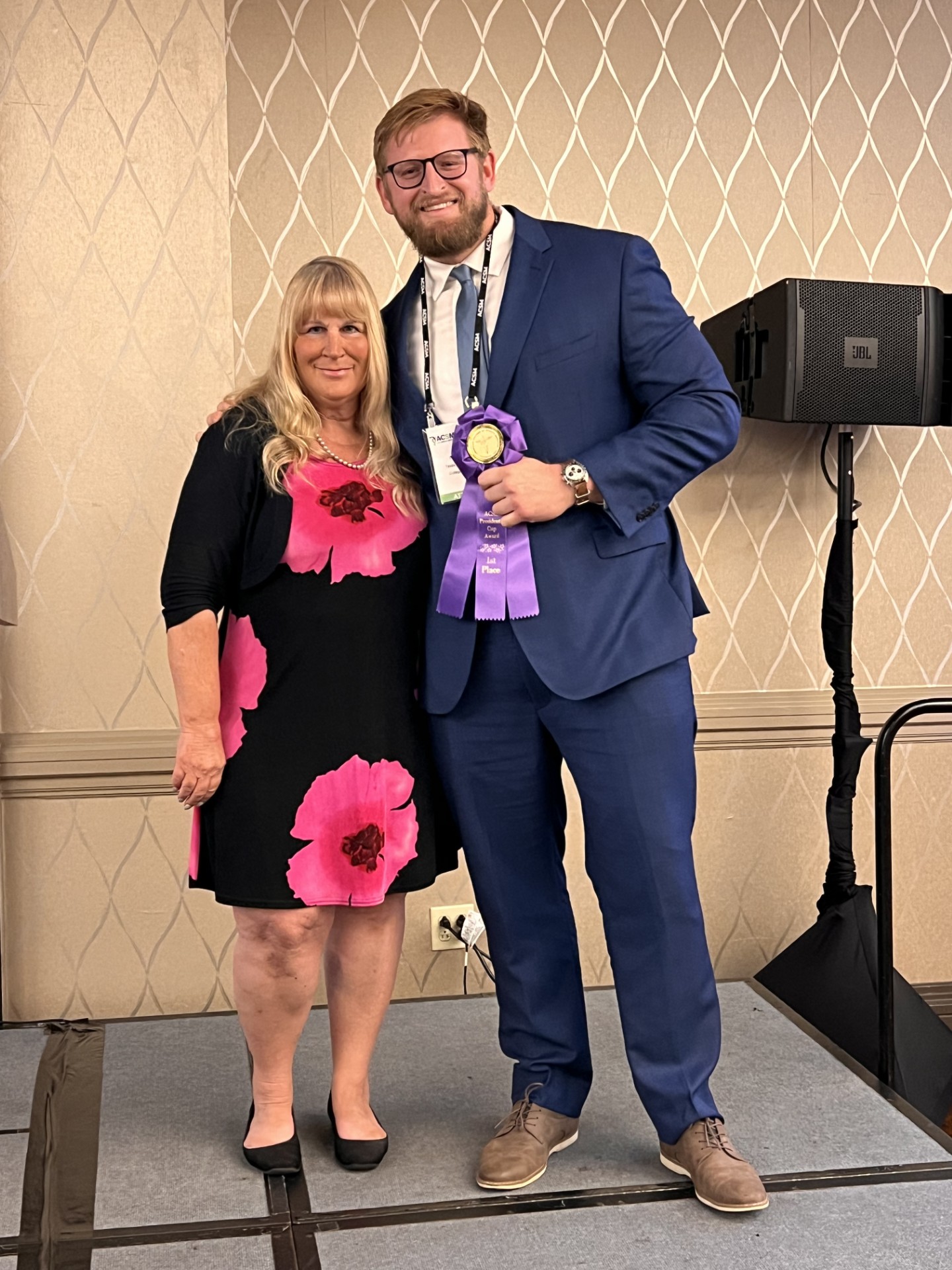 Irene Davis in a black and pink dress standing next to Patrick Ryan wearing a blue suit